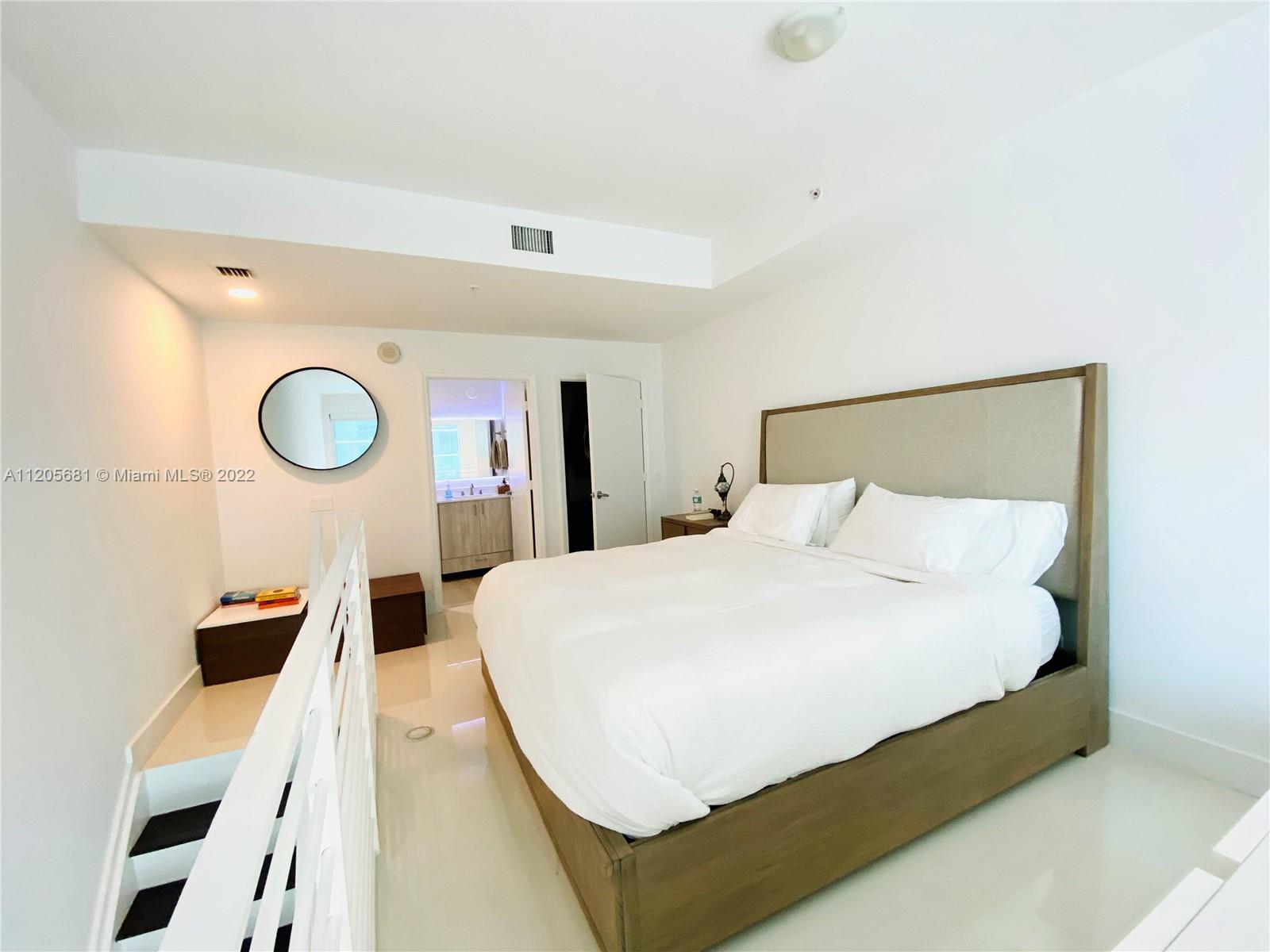 60 Southwest 13th Street, Unit 1412 Miami, FL 33130 - Photo 21 of 39 a large white bed in a white room