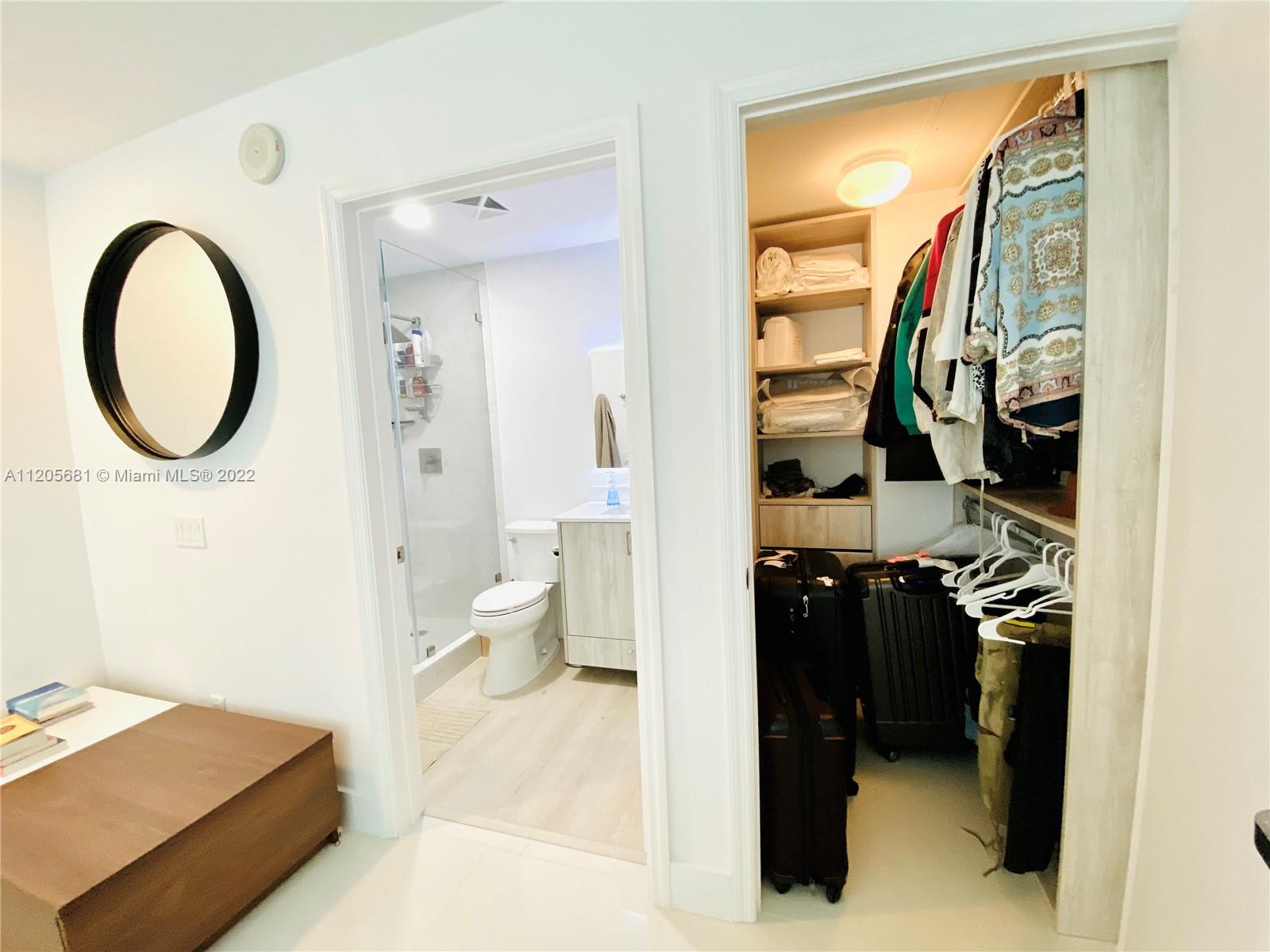 60 Southwest 13th Street, Unit 1412 Miami, FL 33130 - Photo 23 of 39 a bathroom with a sink a toilet and a mirror