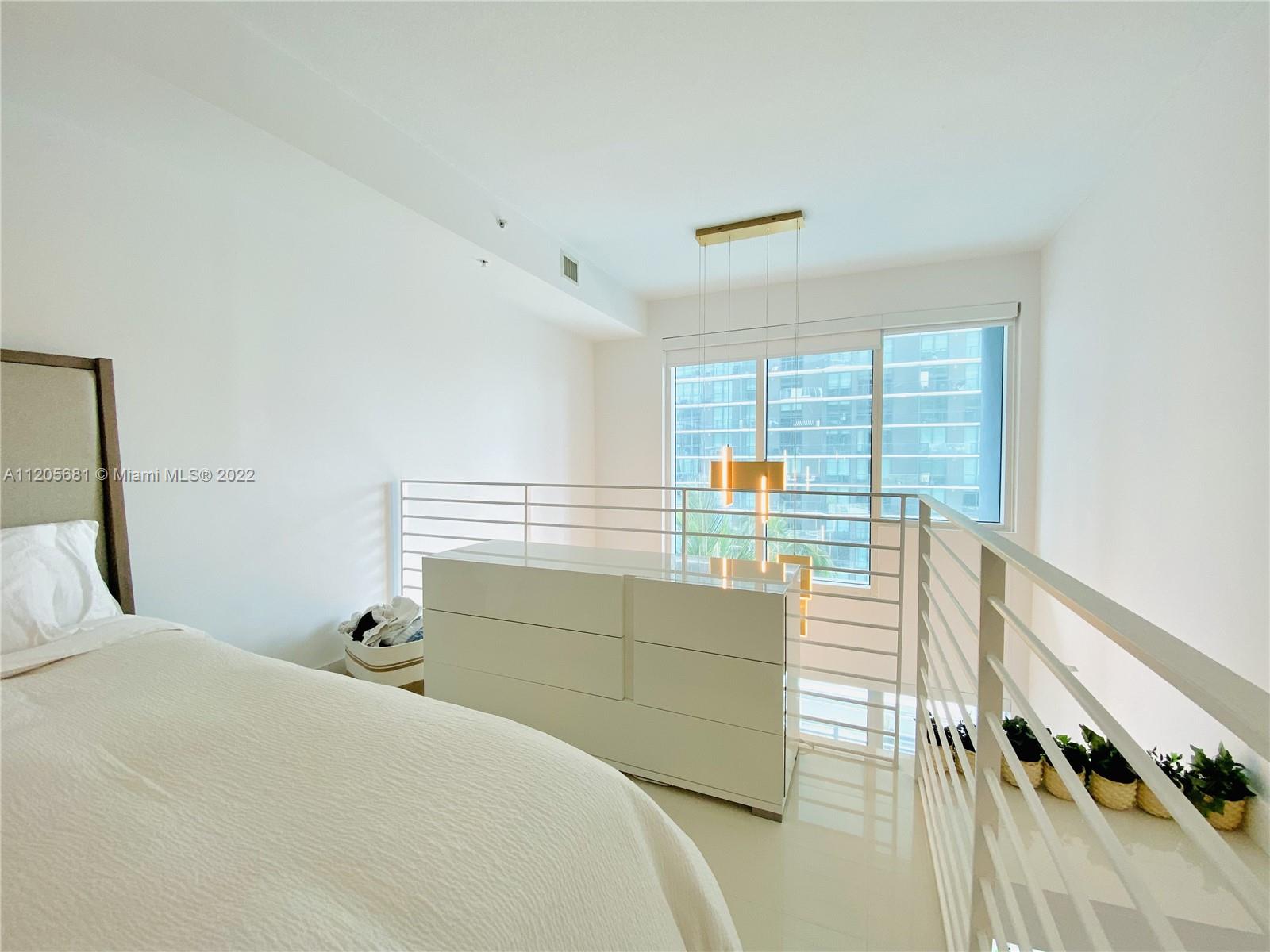 60 Southwest 13th Street, Unit 1412 Miami, FL 33130 - Photo 24 of 39 a bedroom with a bed and a window
