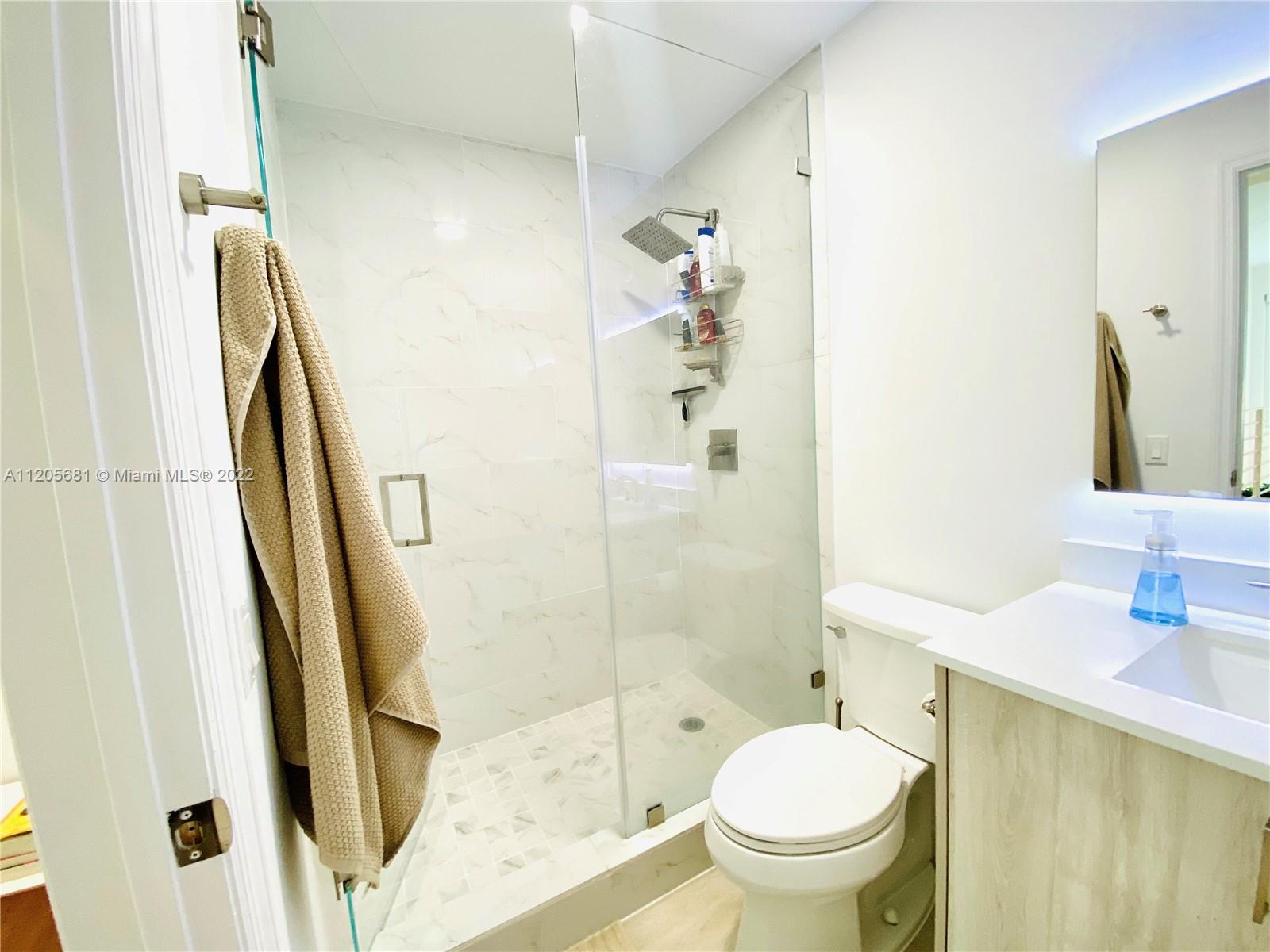 60 Southwest 13th Street, Unit 1412 Miami, FL 33130 - Photo 26 of 39 a bathroom with a granite countertop toilet and a sink