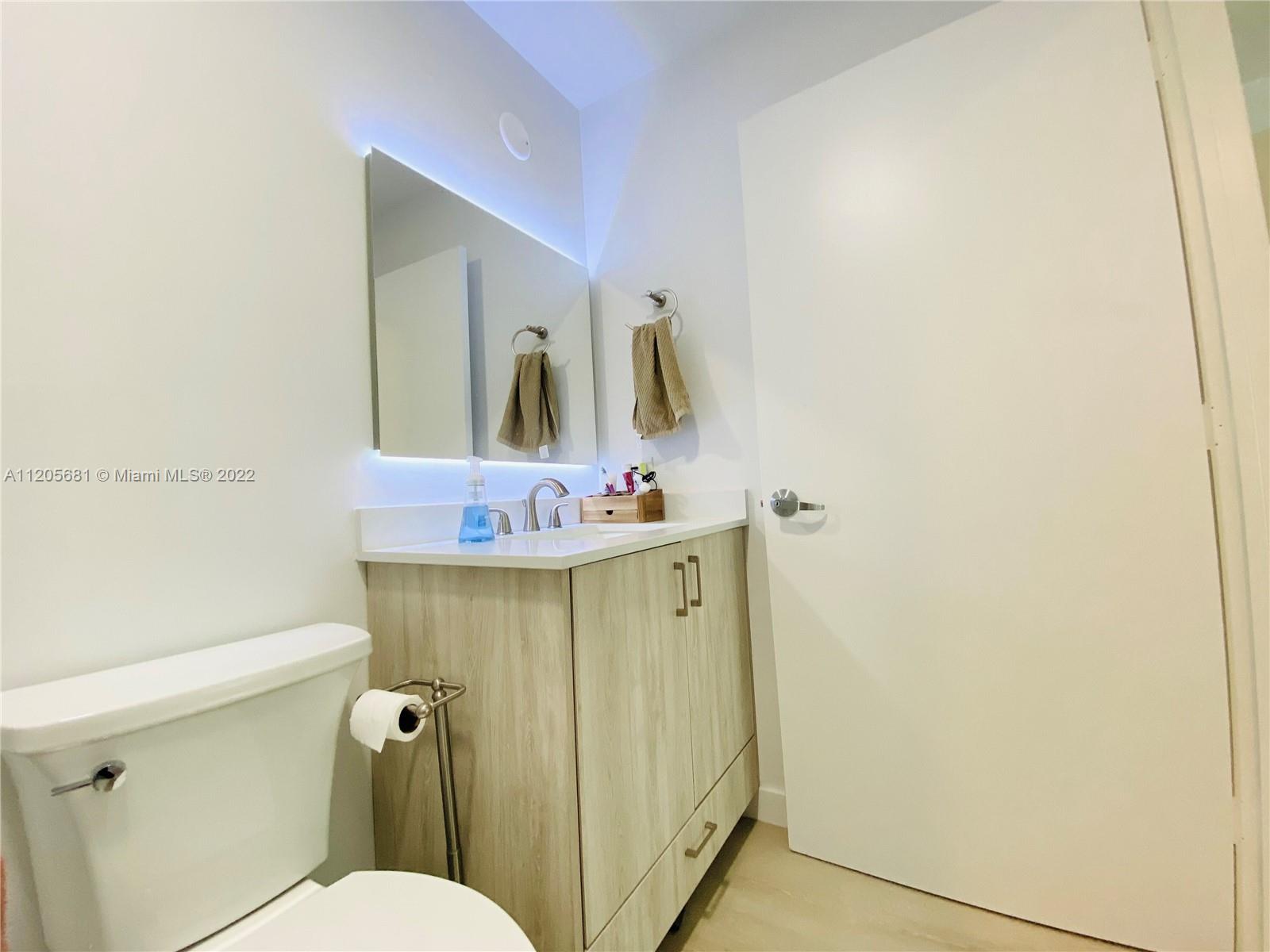 60 Southwest 13th Street, Unit 1412 Miami, FL 33130 - Photo 27 of 39 a bathroom with a sink mirror vanity and toilet