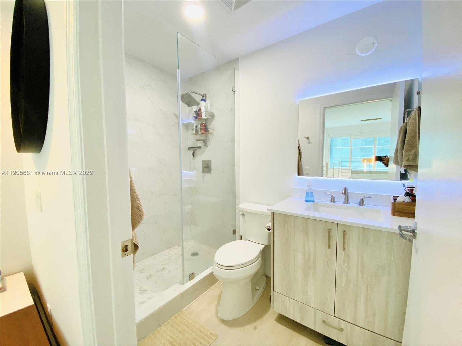 60 Southwest 13th Street, Unit 1412 Miami, FL 33130 - Photo 28 of 39 a bathroom with a sink a toilet and shower