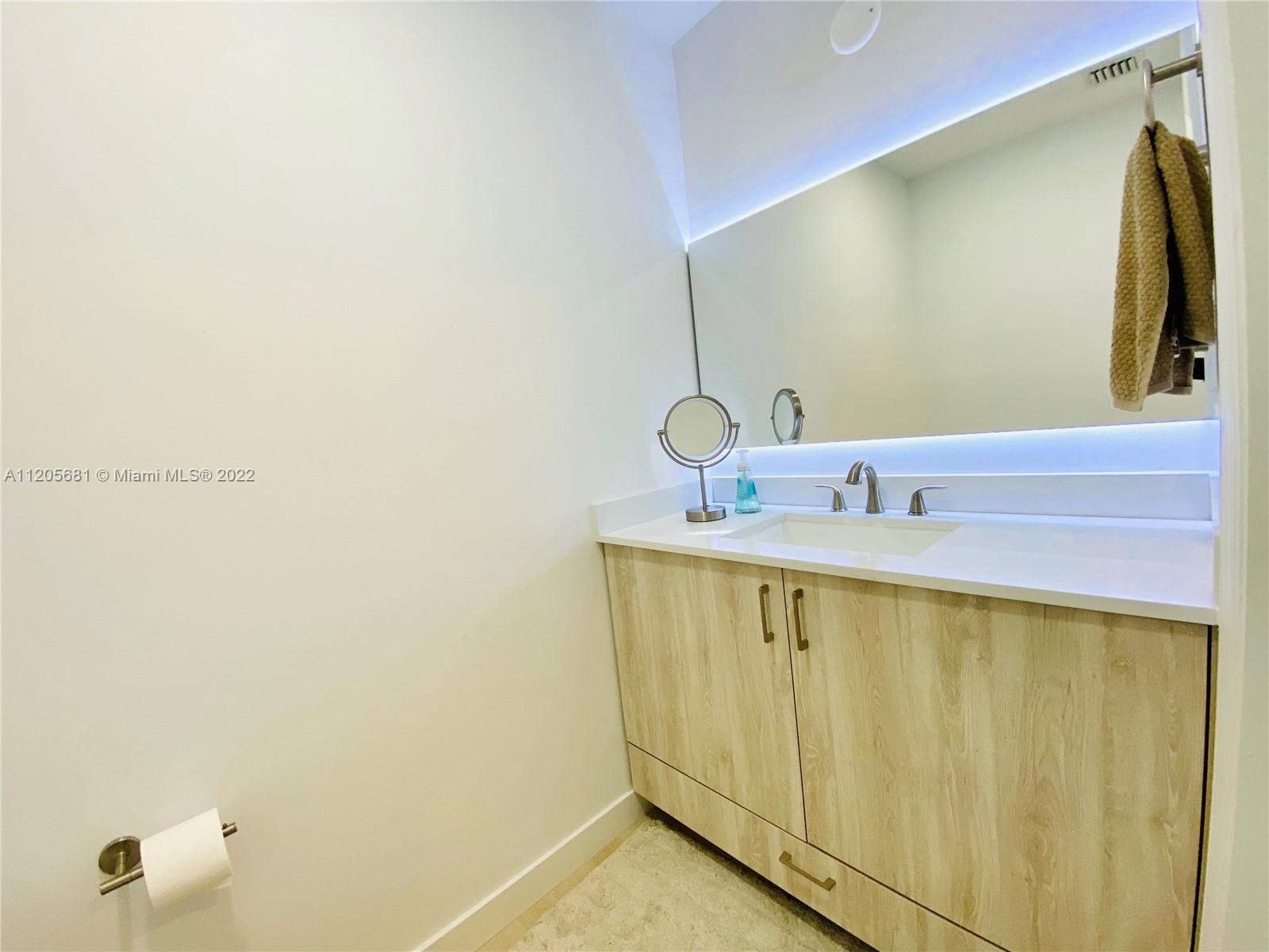 60 Southwest 13th Street, Unit 1412 Miami, FL 33130 - Photo 6 of 39 a bathroom with a sink and a mirror