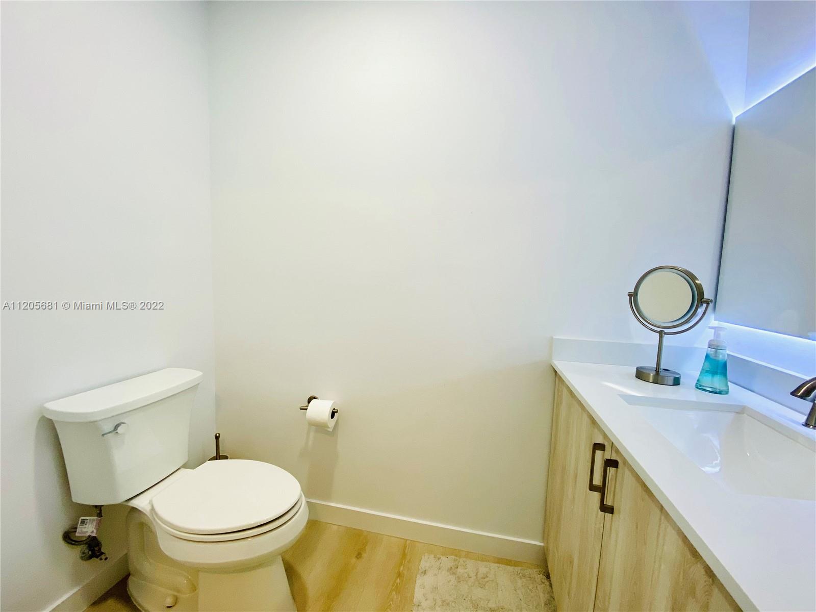 60 Southwest 13th Street, Unit 1412 Miami, FL 33130 - Photo 8 of 39 a bathroom with a granite countertop toilet and a sink