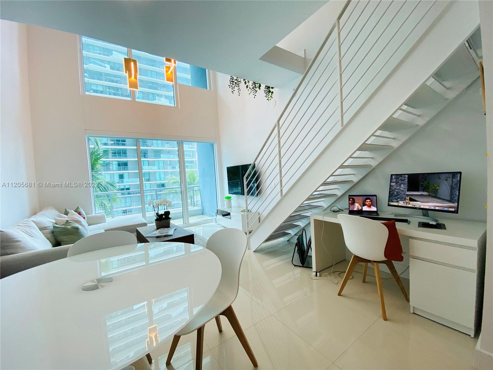 60 Southwest 13th Street, Unit 1412 Miami, FL 33130 - Photo 10 of 39 a living room with furniture and a flat screen tv