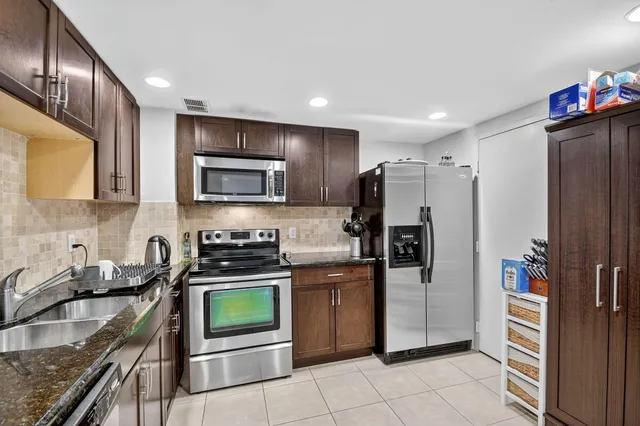 a kitchen with stainless steel appliances granite countertop a sink stove and microwave