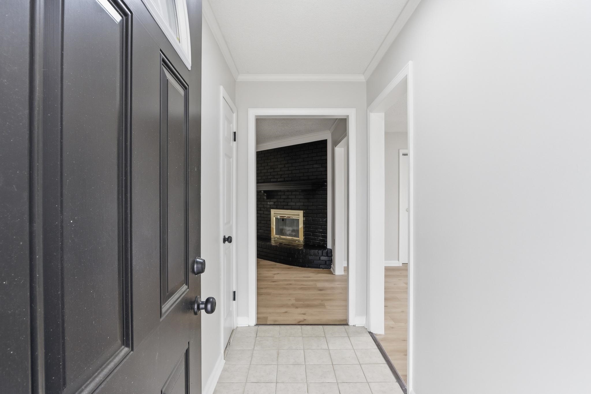 Hall featuring crown molding and light tile patterned floors
