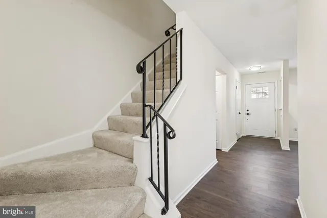 a view of a hallway with wooden floor and staircase