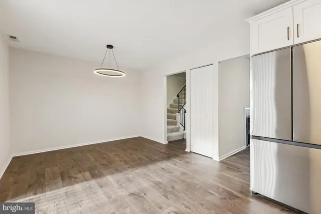 a view of empty room with wooden floor and window