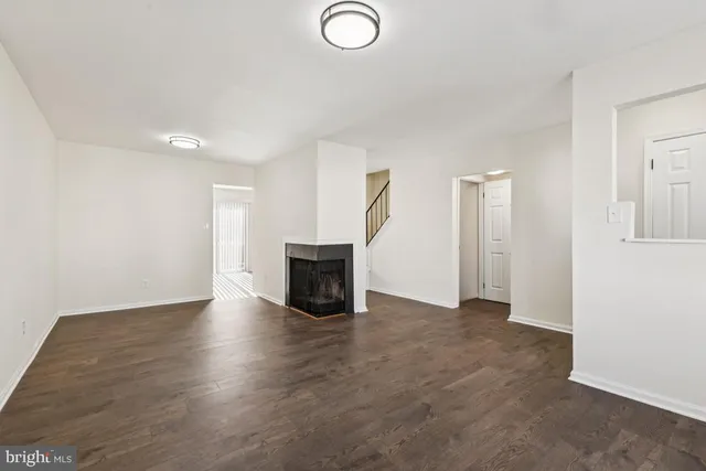 an empty room with wooden floor and fireplace