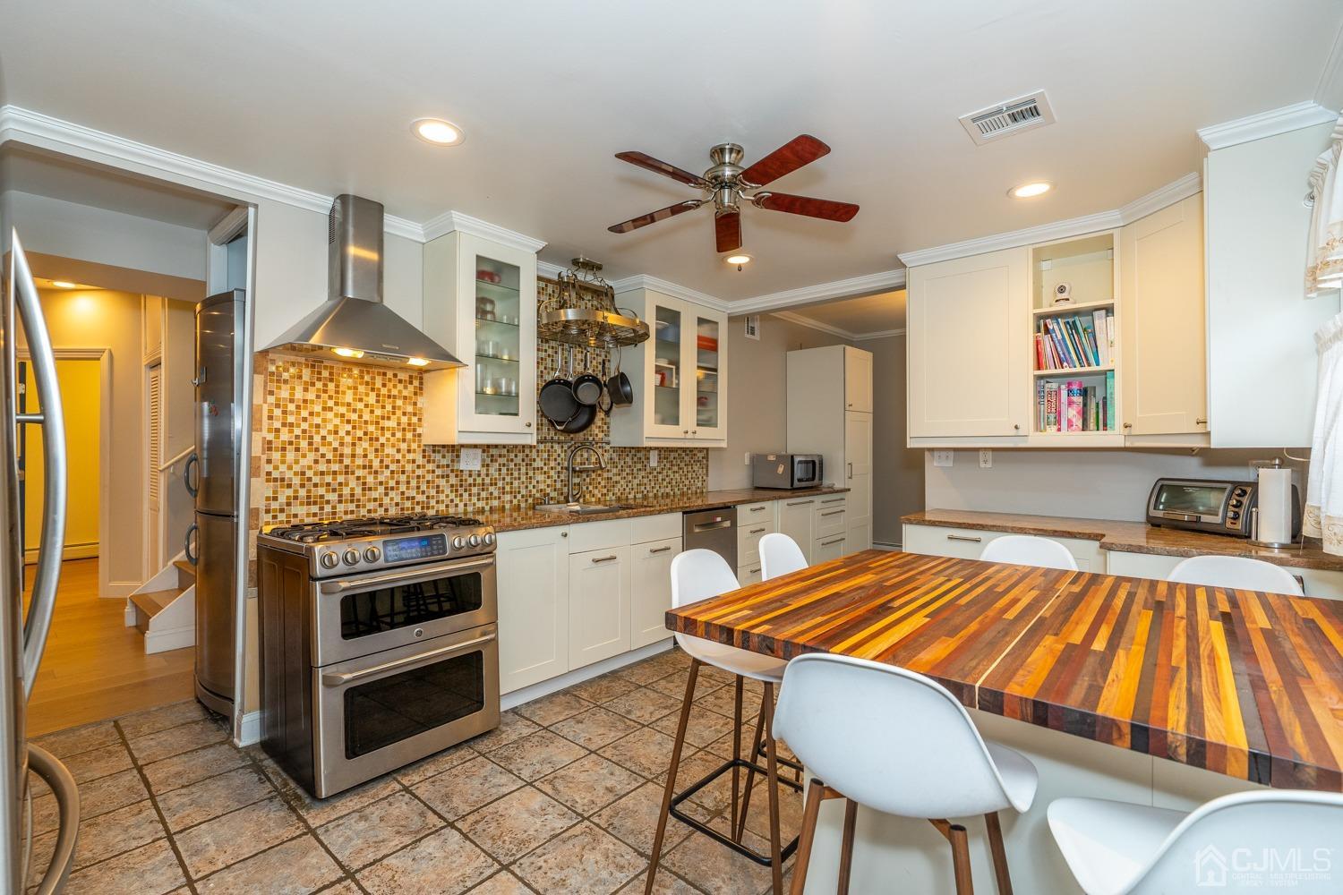 11 Baxter Road Edison, NJ 08817 - Photo 5 of 24 a kitchen with a table chairs sink and cabinets