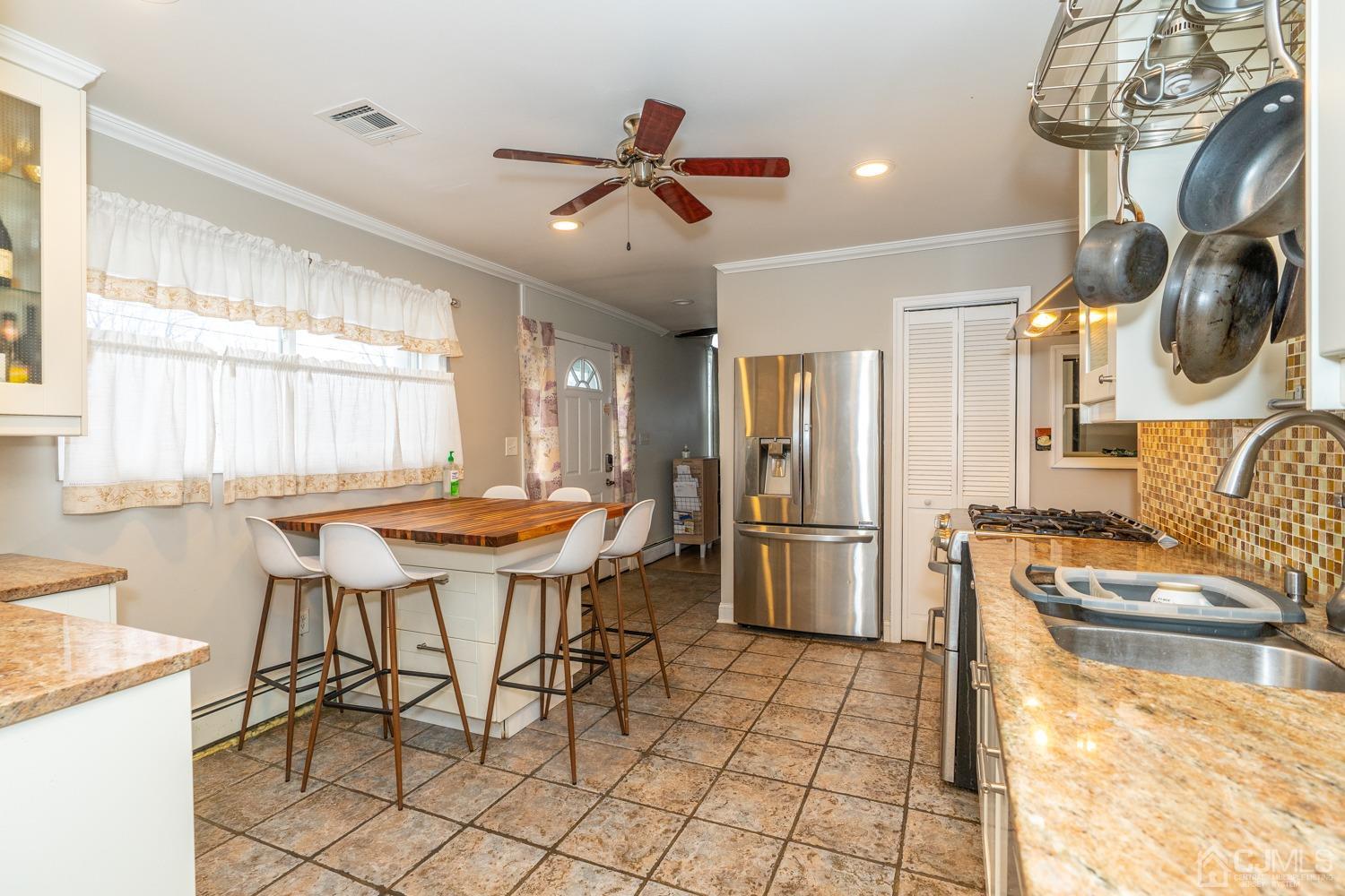11 Baxter Road Edison, NJ 08817 - Photo 7 of 24 a kitchen with stainless steel appliances kitchen island granite countertop a table chairs and a refrigerator