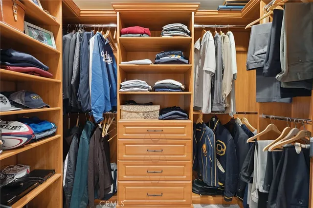a view of walk in closet with clothes and shoes