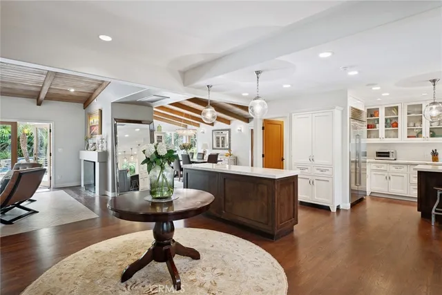 a kitchen with stainless steel appliances granite countertop a stove a refrigerator and a dining table with wooden floor