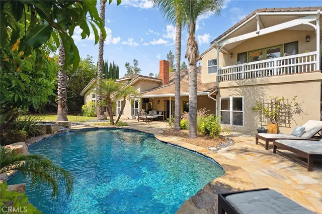 a view of a house with swimming pool and sitting area