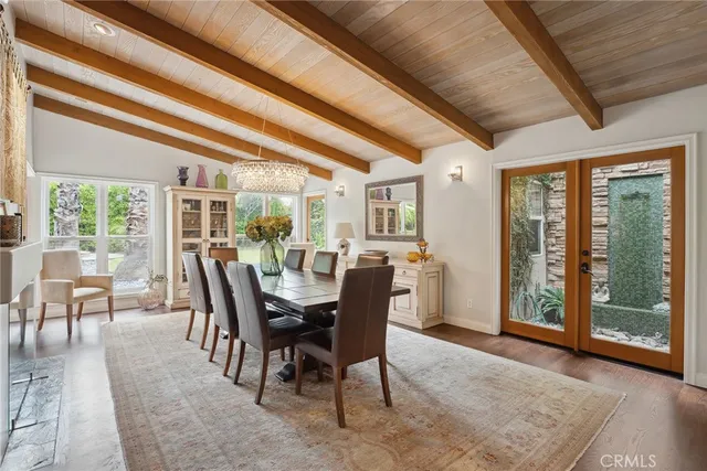 a dining room with furniture a chandelier and wooden floor