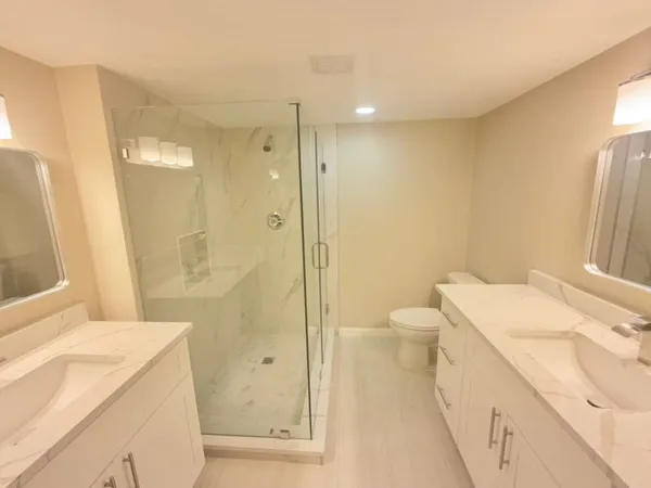 a bathroom with a granite countertop sink a toilet and shower