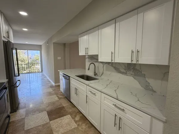 a kitchen with granite countertop white cabinets and sink