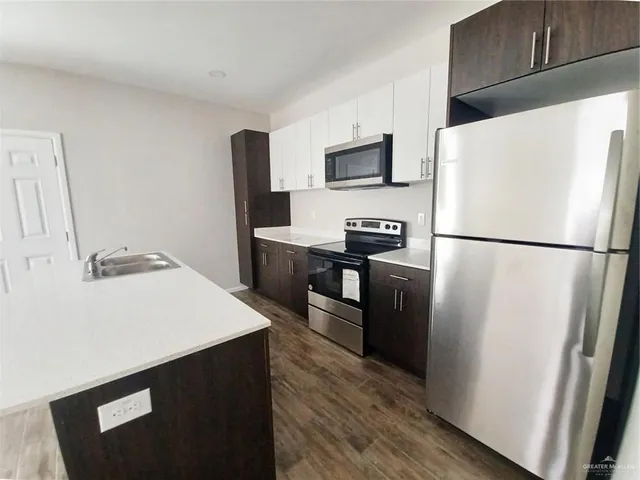 a kitchen with stainless steel appliances a refrigerator stove microwave and sink