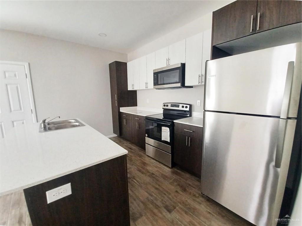 811 East Starr Road, Unit A Mercedes, TX 78570 - Photo 3 of 10 a kitchen with stainless steel appliances a refrigerator stove microwave and sink