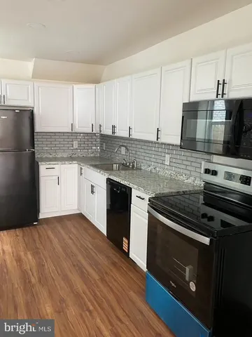 a kitchen with a sink a microwave a refrigerator and cabinets