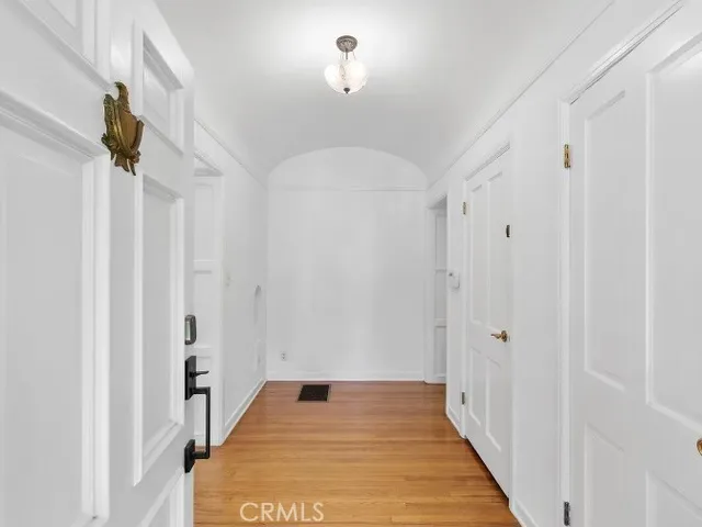 a view of a hallway with wooden floor and staircase