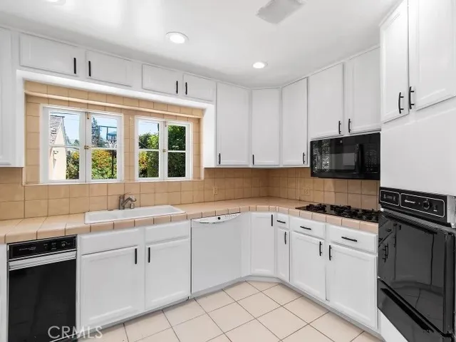 a kitchen with white cabinets appliances and a sink