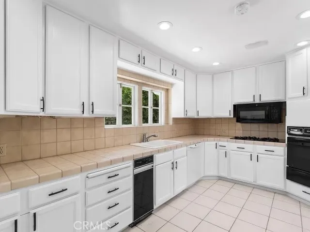 a kitchen with granite countertop white cabinets white stainless steel appliances with a sink and dishwasher