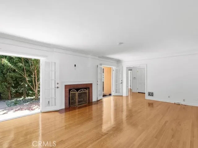 an empty room with fireplace and a window
