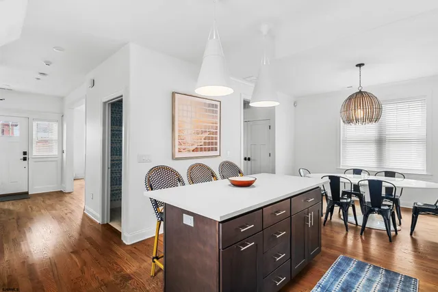 a kitchen with a table chairs and wooden floor