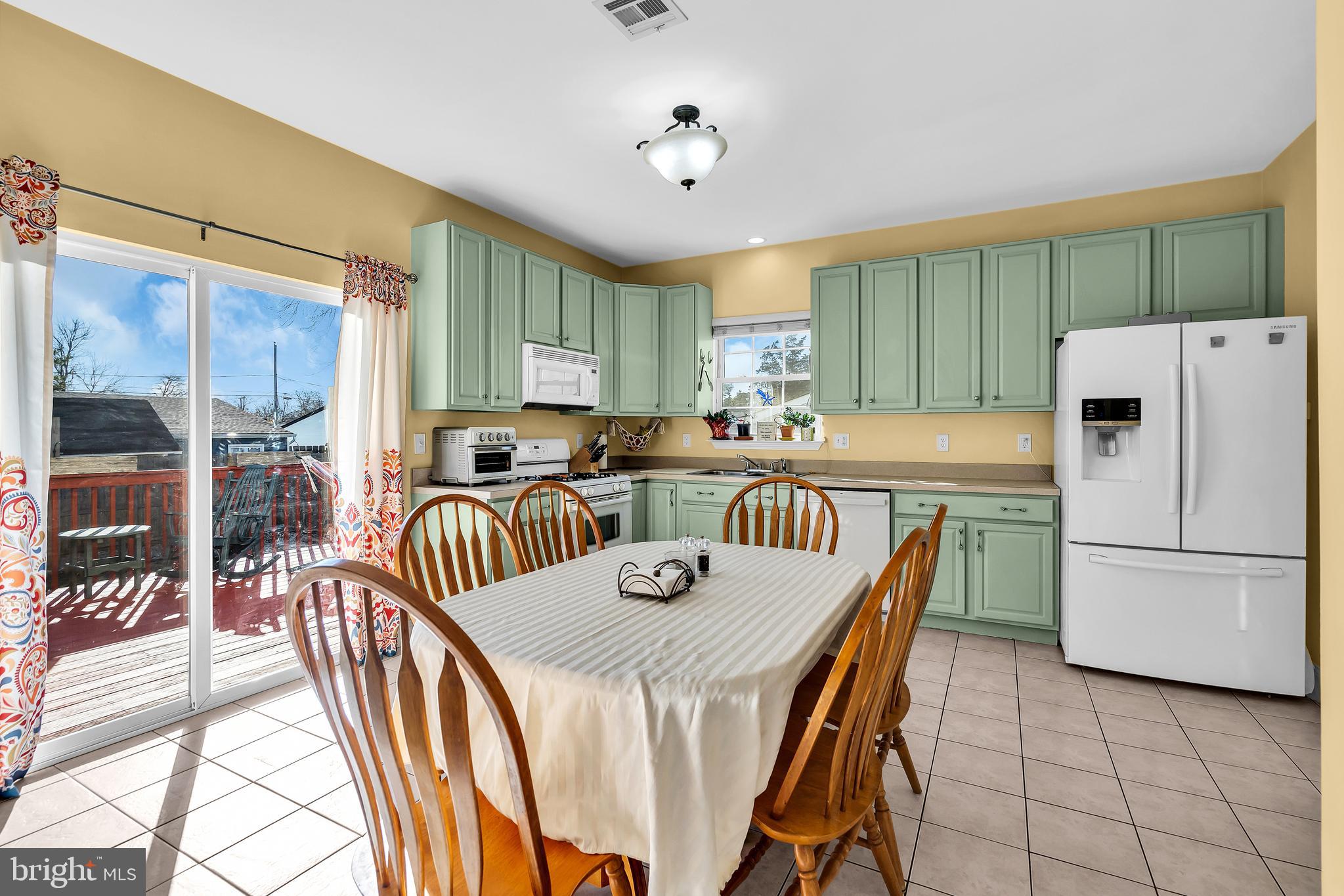 1007 Inland Road Forked River, NJ 08731 - Photo 9 of 27 a kitchen with granite countertop a dining table chairs and a refrigerator