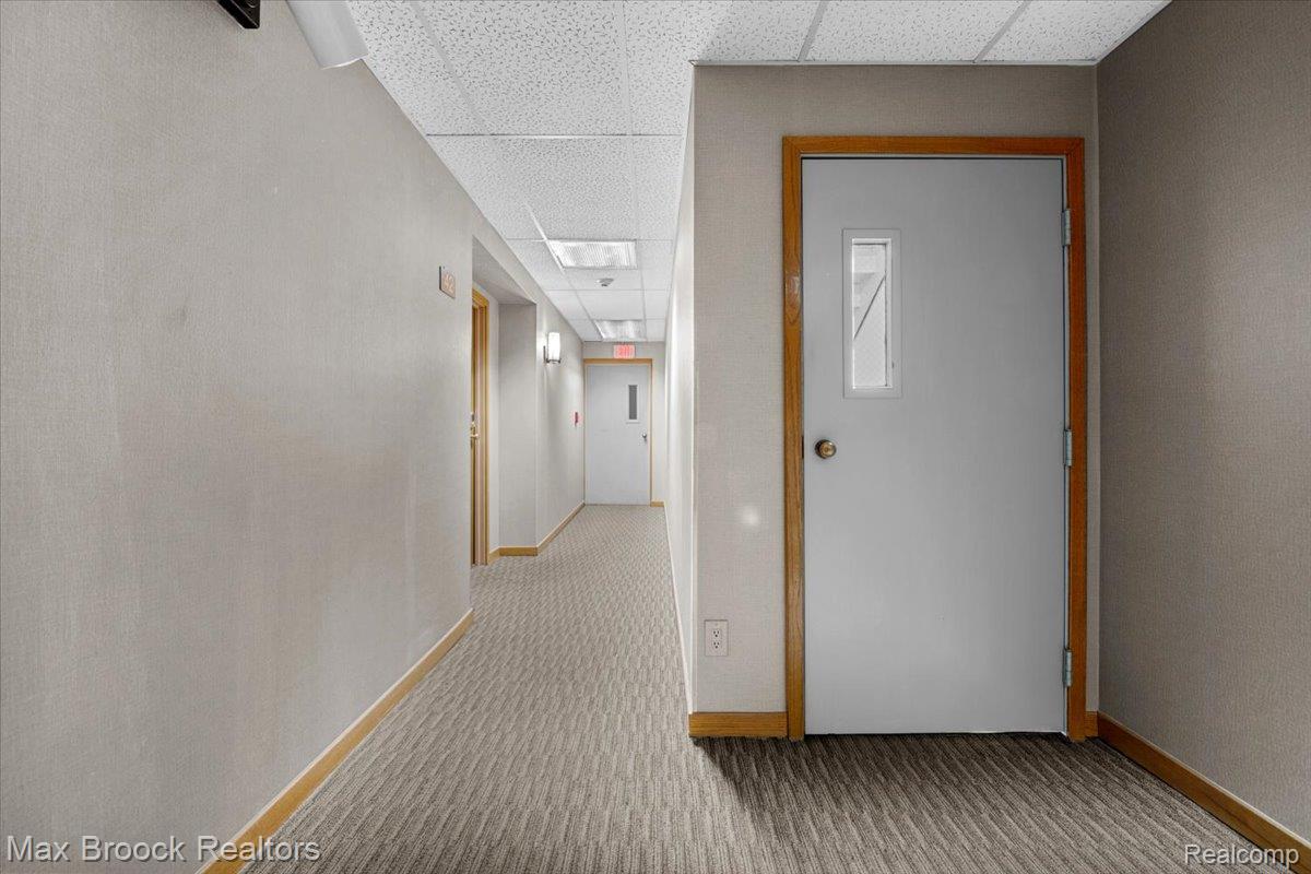 Corridor with a drop ceiling and carpet