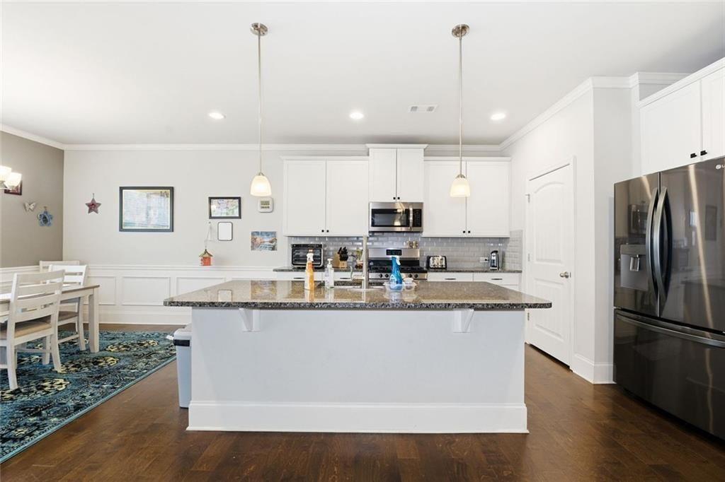419 After Glow Summit Canton, GA 30114 - Photo 22 of 41 a kitchen with stainless steel appliances granite countertop a sink a stove a refrigerator and island with wooden floor