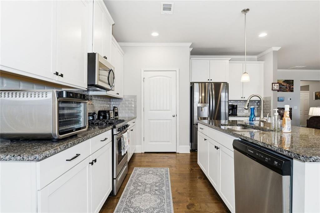 419 After Glow Summit Canton, GA 30114 - Photo 24 of 41 a large kitchen with stainless steel appliances granite countertop a stove a sink and a refrigerator