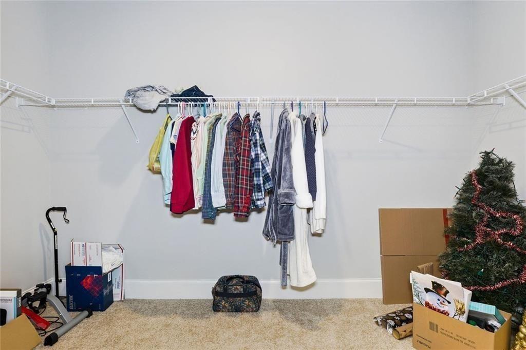 419 After Glow Summit Canton, GA 30114 - Photo 34 of 41 a view of walk in closet with clothes and shoes
