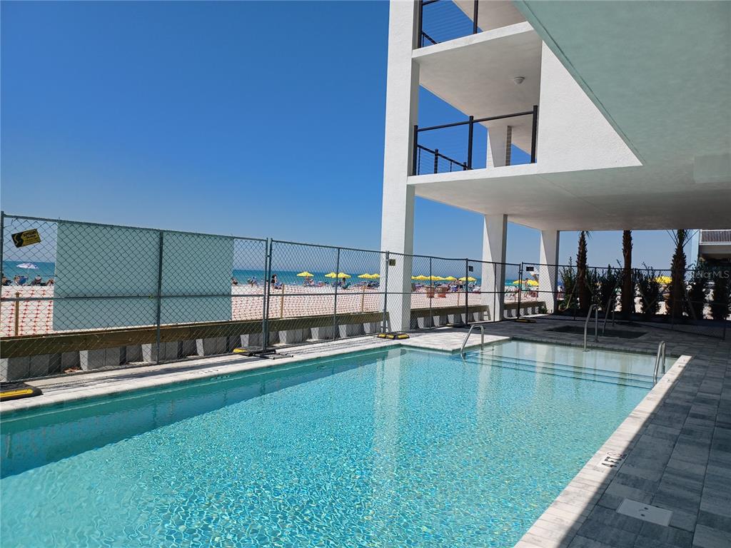 14048 Gulf Boulevard, Unit 401 Madeira Beach, FL 33708 - Photo 11 of 14 a view of a swimming pool with outdoor seating