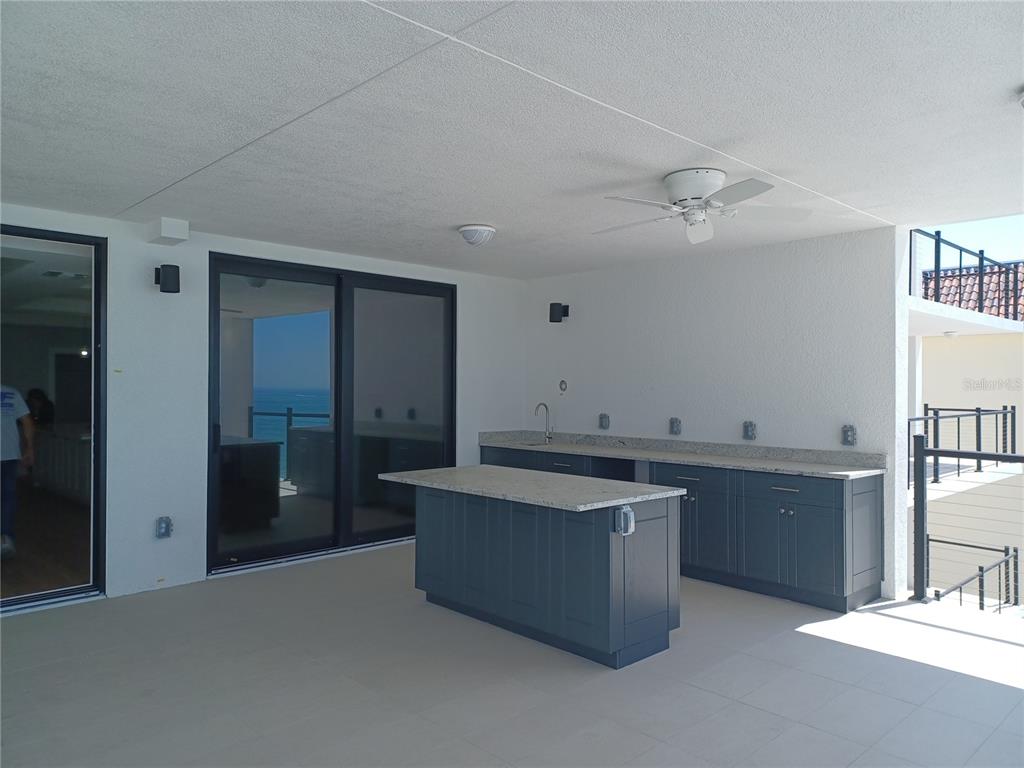 14048 Gulf Boulevard, Unit 401 Madeira Beach, FL 33708 - Photo 8 of 14 a kitchen with stainless steel appliances granite countertop a sink and a refrigerator