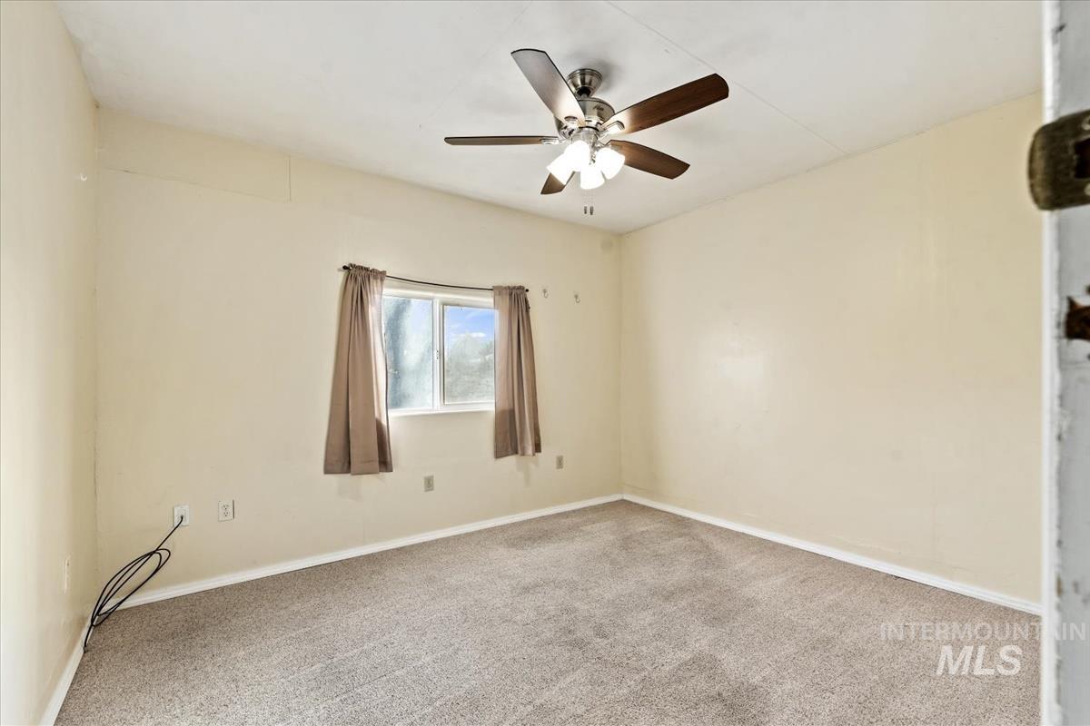 351 East 3rd Street Kuna, ID 83634 - Photo 21 of 42 Carpeted empty room featuring baseboards and a ceiling fan