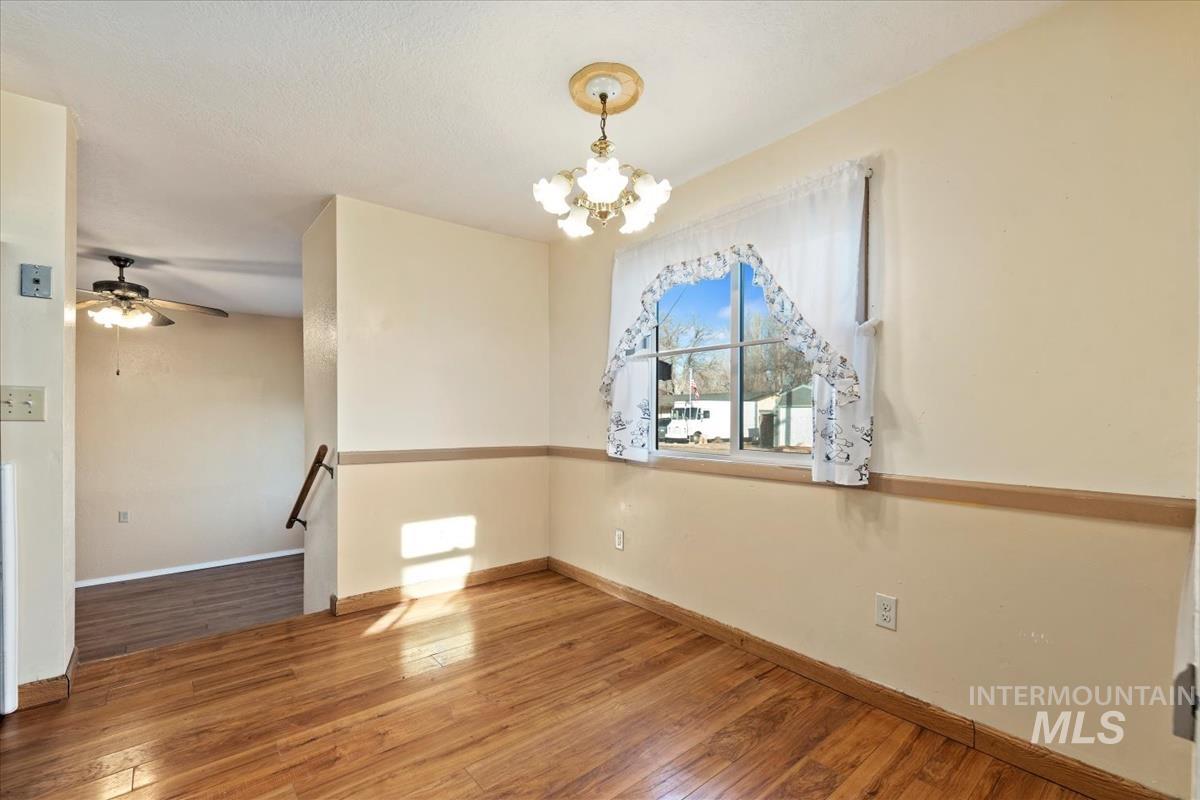 351 East 3rd Street Kuna, ID 83634 - Photo 25 of 42 Empty room featuring light wood-style flooring, suspended lighting, and a ceiling fan