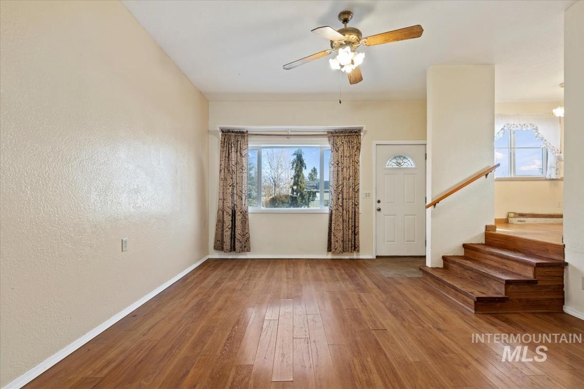 351 East 3rd Street Kuna, ID 83634 - Photo 4 of 42 Foyer entrance with wood-type flooring, a ceiling fan, and a textured wall