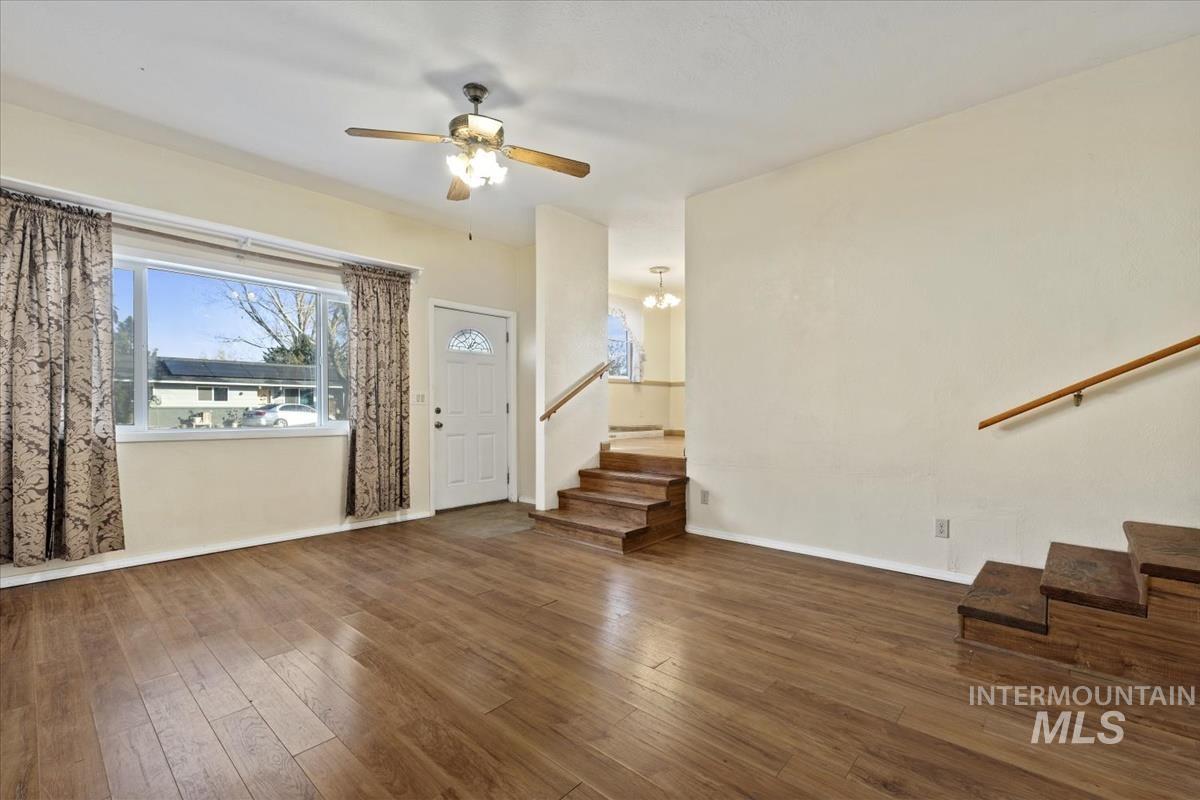 351 East 3rd Street Kuna, ID 83634 - Photo 5 of 42 Unfurnished living room featuring plenty of natural light, dark wood finished floors, ceiling fan, and hanging lights