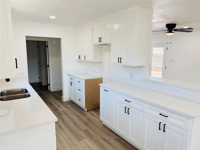 a kitchen with cabinets appliances and a wooden floor