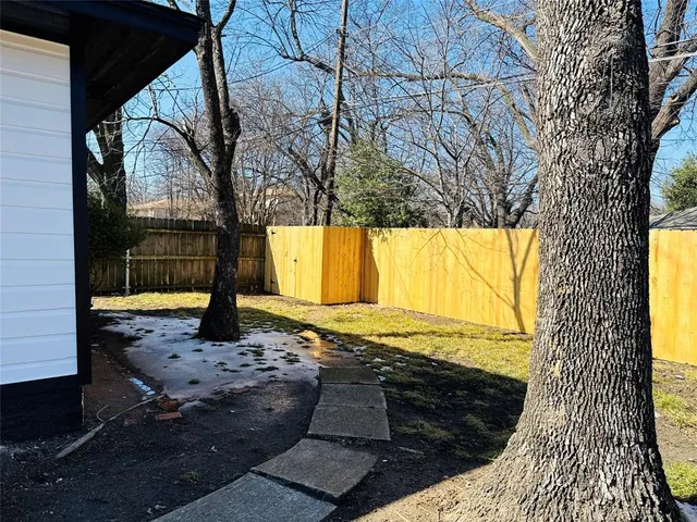 a view of a yard with wooden fence