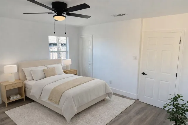a bedroom with a large bed and a potted plant