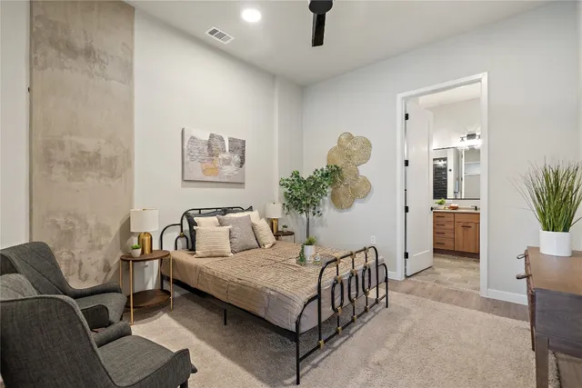 a bedroom with a bed a couch and a potted plant