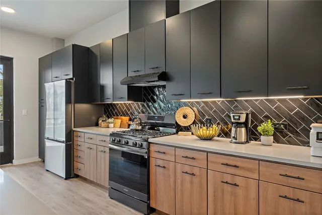 a kitchen with stainless steel appliances granite countertop a stove and a refrigerator