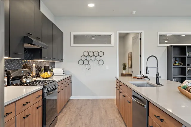 a kitchen with stainless steel appliances granite countertop a sink stove and refrigerator