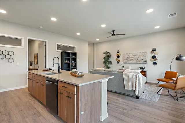 a kitchen with stainless steel appliances granite countertop a sink stove and wooden floor