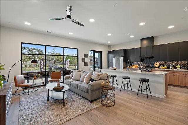 a living room with lots of furniture and view of kitchen