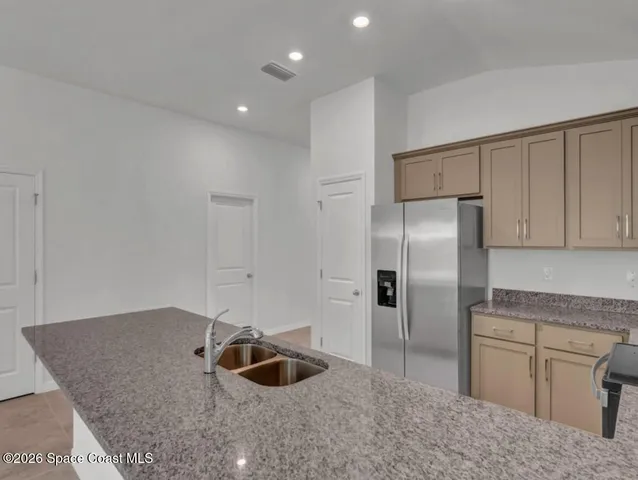 a kitchen with stainless steel appliances granite countertop a refrigerator and a sink
